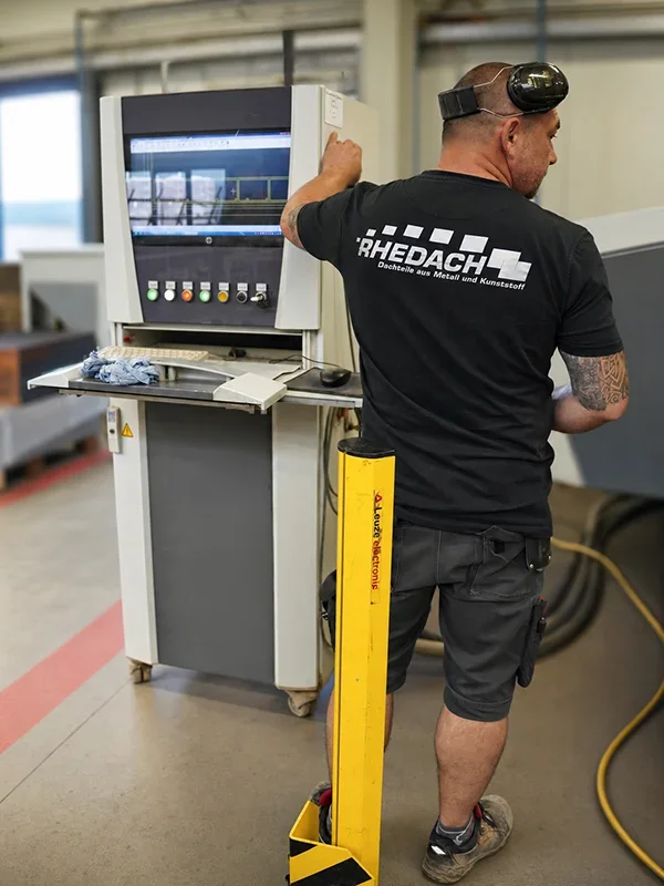 Rhedach Mitarbeiter bedient eine CNC-Maschine in der Fertigung